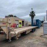 A large truck with two men standing on it.