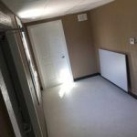 A room with a door open and a window.