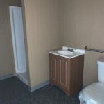 A bathroom with a toilet, sink and shower.