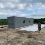 A man walking on the ground near a building.