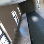 A room with many windows and a long bench