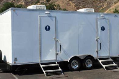A white trailer with two toilets and steps.