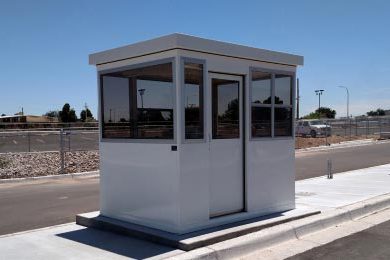 A white booth sitting on the side of a road.