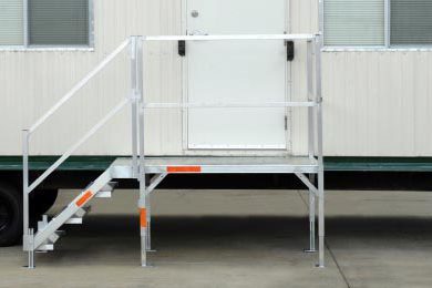 A white trailer with stairs and a ramp.