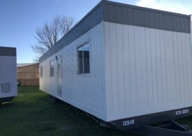 A trailer with a white and gray exterior.