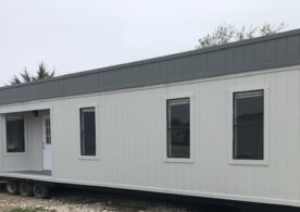 A white mobile home with windows and doors.