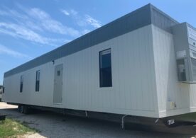 A white trailer with windows and doors on the side.