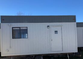A white trailer with a door and windows.