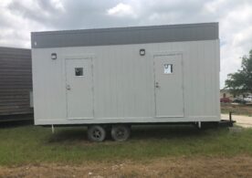 A white trailer with two windows and doors.