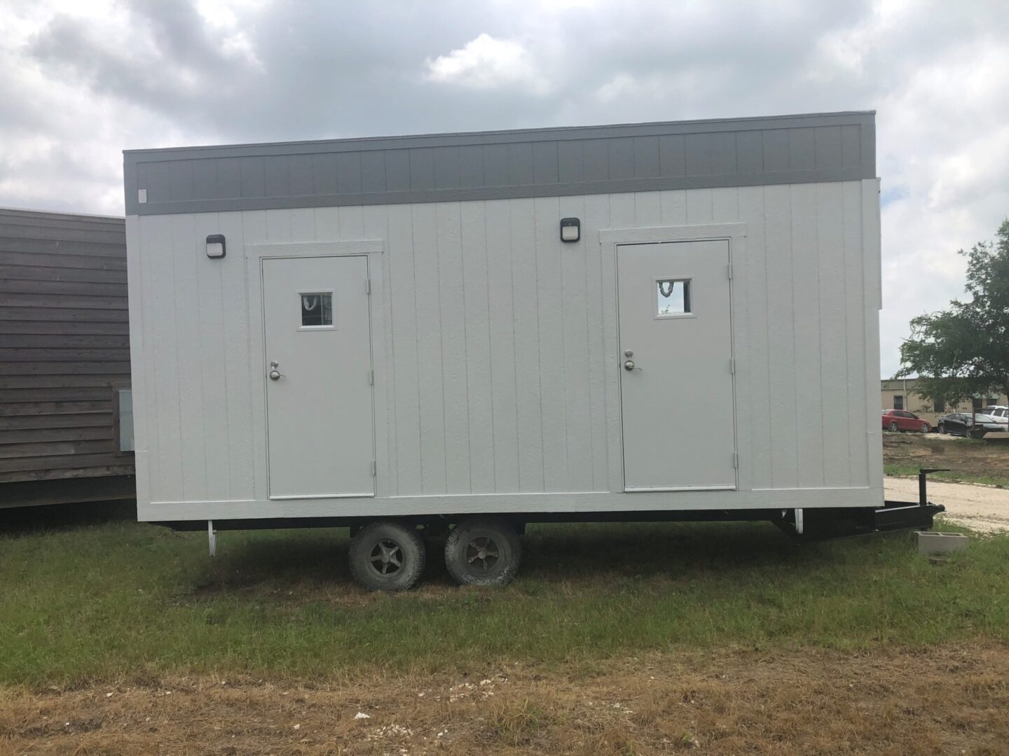 A white trailer with two windows and doors.