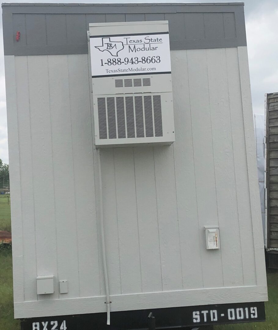 A white trailer with a sign on the side of it.
