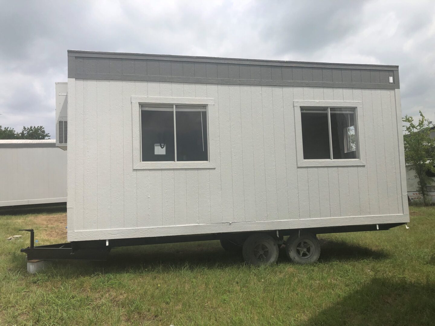 A trailer with two windows and a door.