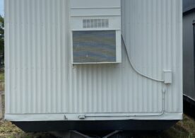 A white trailer with a sign on the side of it.