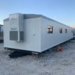 A trailer with many windows and doors on the side of it.