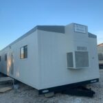 A white trailer with a door open on the side.