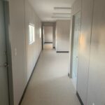 A hallway with many doors and windows in it