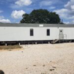 A mobile home sitting on top of gravel.
