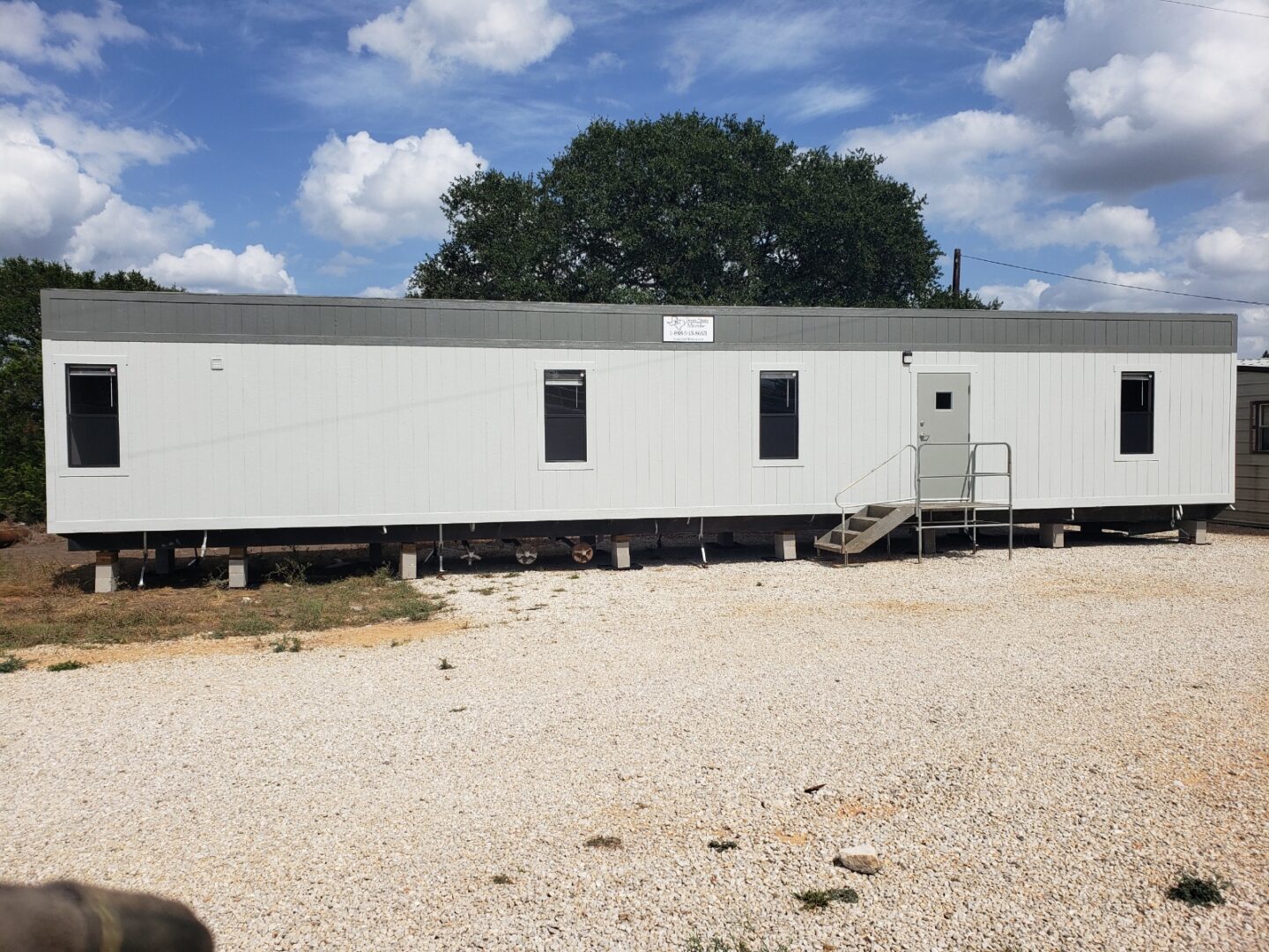 A mobile home sitting on top of gravel.