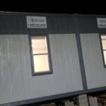 A building with two windows and signs on the side.