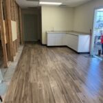 A room with wood floors and white cabinets.