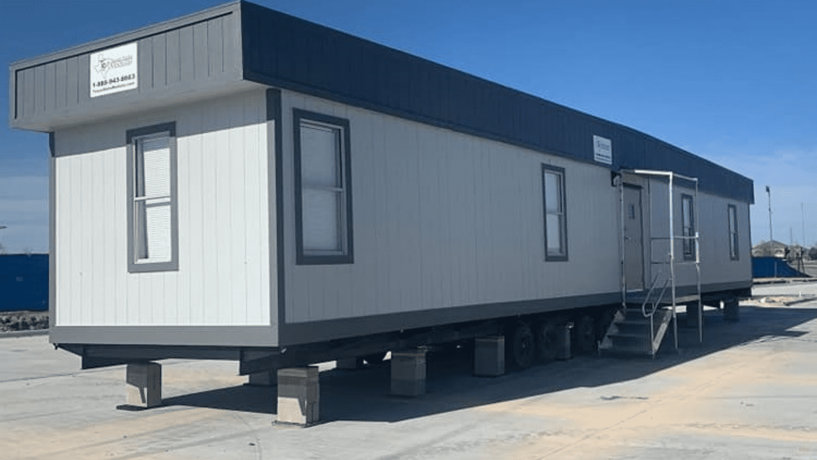 A trailer with two windows and a door.