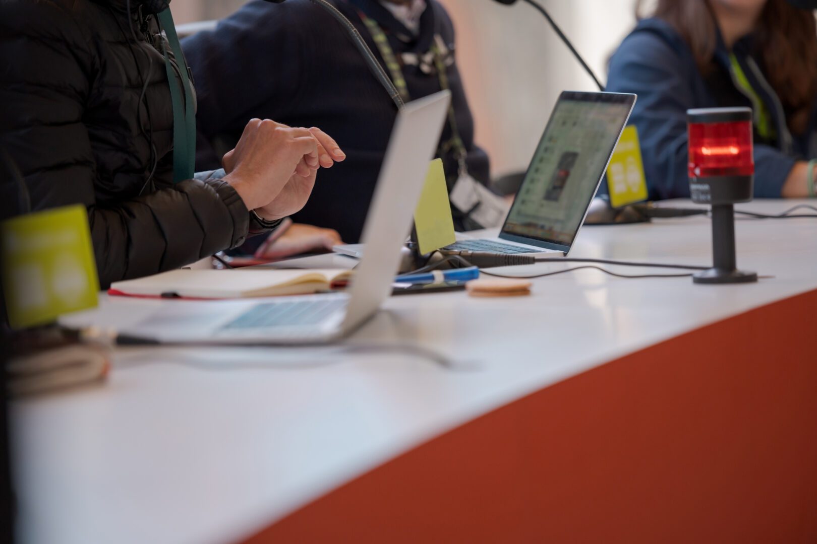 A group of people sitting at a table with laptops.