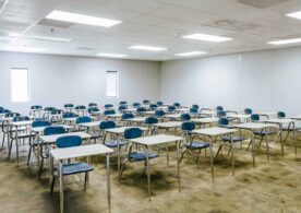 A classroom with many blue chairs and tables
